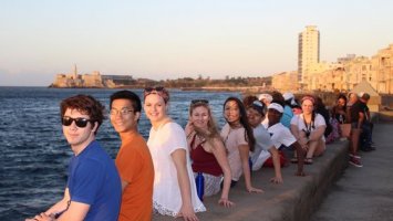 Students sitting on the Malecón looking over the Havana harbor during their spring break in Cuba